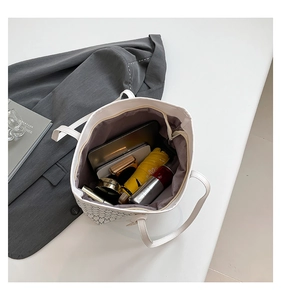 Internal view of a large white tote bag with letter M prints and spacious storage