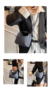 Close-up of blue woven crossbody bag showing textured cube design and crossbody strap
