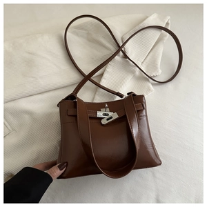 Detailed shot of brown leather bag showing metallic twist-lock and fine texture