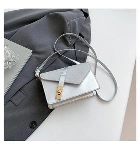 Detail of silver metallic crossbody bag featuring glitter flap and gold twist lock closure