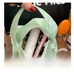 Top view of spacious mint green cosmetic bag interior holding various makeup essentials