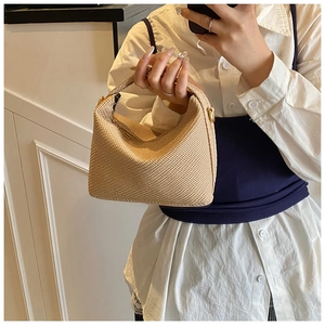 Close-up of beige woven handbag with diamond texture and elegant gold metal clasp