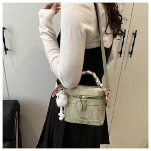 Detail of light green marble vanity bag with silk scarf handle and pompom charm
