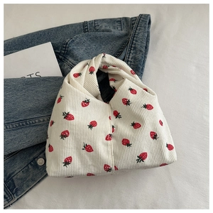 Détail du sac à main en velours côtelé à imprimé fraises et poignée nouée unique