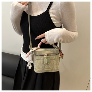 Detail of light green marble texture box bag with silk scarf handle and plush pendant