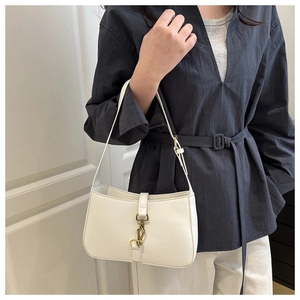 Détail du sac à bandoulière en cuir blanc avec boucle dorée sur fond minimaliste