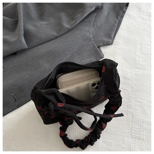 Interior storage view of corduroy shoulder bag showing wallet and phone capacity