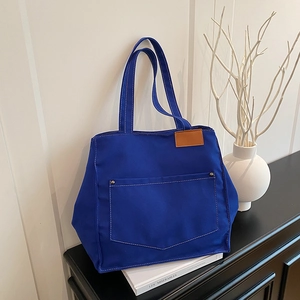 Sac fourre-tout en toile bleu roi avec étiquette en cuir et rivets en décor minimaliste