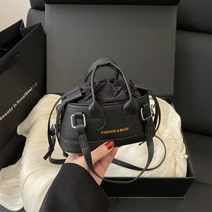 Mini black lychee leather handbag with gold lettering and adjustable shoulder strap
