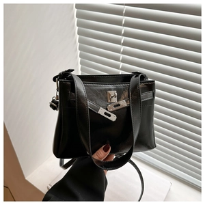 Detailed close-up of a black vintage handbag with glossy finish and silver twist lock
