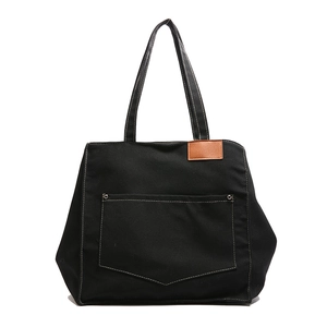 Sac fourre-tout noir minimaliste en toile avec grande poche avant et rivets métalliques