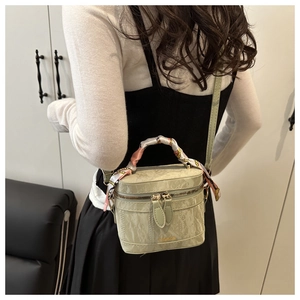 Close-up of light green mini box bag with marble texture and floral silk scarf detail