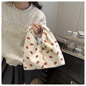 Détail du sac cabas en velours côtelé blanc cassé avec imprimé fraise et texture côtelée