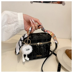 Detail of black pleated velvet crossbody bag with silk scarf handle and plush charm