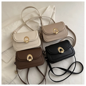 Detail showing vintage shoulder bags in four colors with U-shaped gold hardware buckles