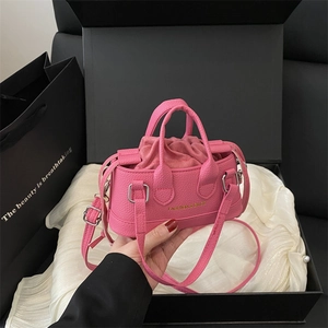 Pink lychee grain mini shell bag with gold lettering and drawstring pouch in gift box
