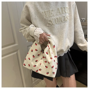 Détail du sac à main en velours côtelé crème avec imprimés fraises et texture douce