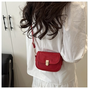 Model view of a vibrant red lychee pattern crossbody bag with a metal push-lock closure
