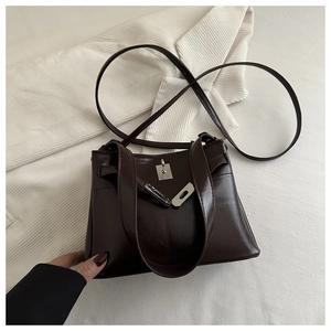 Detailed close-up of dark brown glossy leather tote bag featuring a silver metal twist-lock