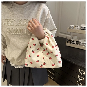 Détail de la texture d'un sac à main en velours côtelé blanc cassé à imprimé fraise