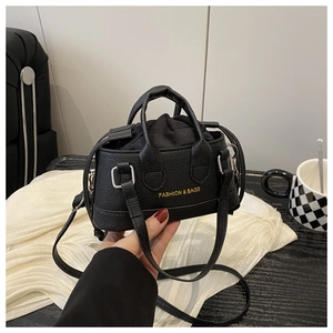Detail of black mini shell bag with lychee texture and drawstring closure detail