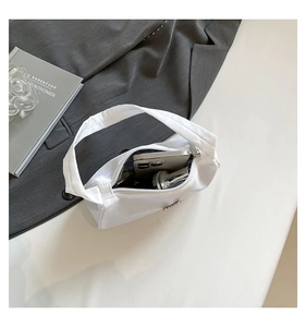 Detailed interior view of a white minimalist shoulder bag with silver zipper and large capacity
