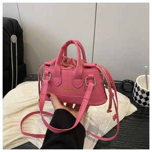 Close-up of pink mini handbag showing litchi texture and drawstring interior pocket