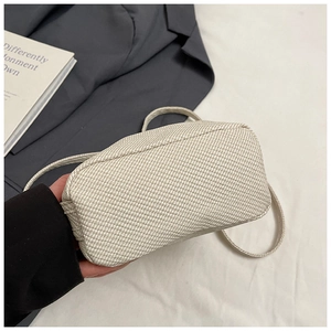 Close-up of woven fabric crossbody bag showing base structure and stitching detail