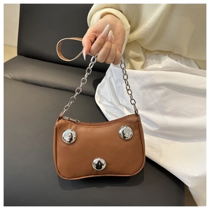 Detail of a brown crescent bag featuring silver studs and a dual chain leather strap