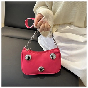 Detailed view of pink crescent bag with silver metallic studs and chain strap