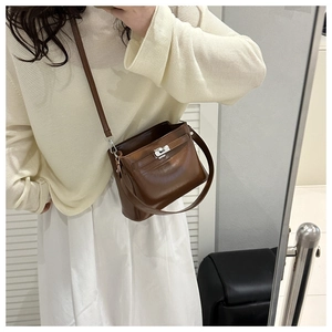 Detail of vintage brown leather bag with metallic buckle closure and adjustable strap