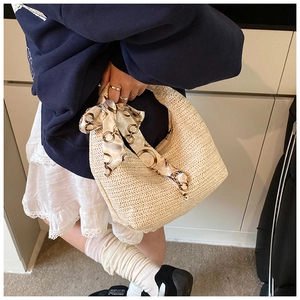 Détails du sac à main en paille tressé crème avec un foulard en soie décoratif au manche
