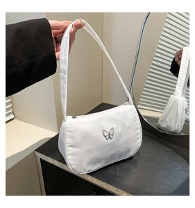 Close-up of a white minimalist underarm bag featuring a silver butterfly metallic ornament