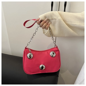 Detailed view of pink crescent bag with silver metallic ball accents and chain strap