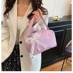 Close-up of lavender mini bag with delicate white lace bow and pearl charm detail