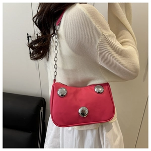 Hot pink crescent bag featuring silver metallic studs and chain strap on a model
