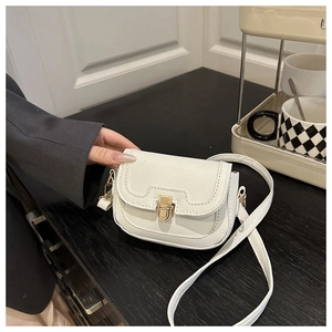 Detailed close-up of white lychee pattern leather and gold metal push lock on handbag