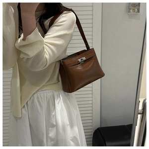 Brown lychee leather shoulder bag with silver clasp lock shown in a casual mirror selfie