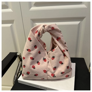Détail du sac cabas en velours côtelé rose avec motifs fraises et anse à nœud unique