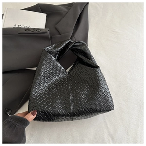 Close-up of black woven leather texture and hobo design of the large shoulder bag