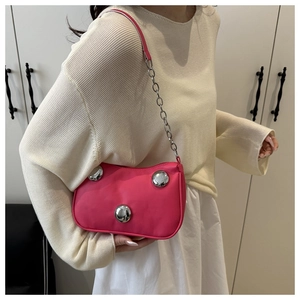 Detail of rose pink moon bag featuring silver spherical metal studs and thin chain strap