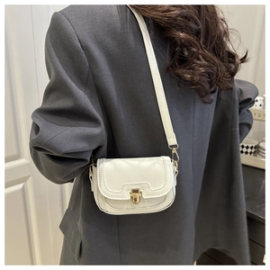 Detail of white PU leather crossbody bag featuring a golden clasp and textured finish