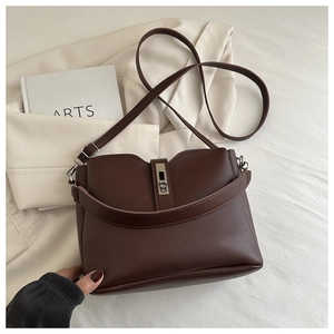 Vue détaillée du sac seau en cuir marron foncé avec boucle en métal et bandoulière réglable