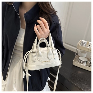 Detail of white lychee pattern mini shell bag with gold fashion text and drawstring side