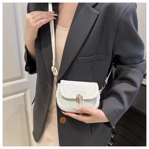 Close-up of white lychee leather crossbody bag with gold clasp shown on a model