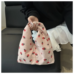 Détail du sac à main en velours côtelé rose avec motifs de fraises et texture douce