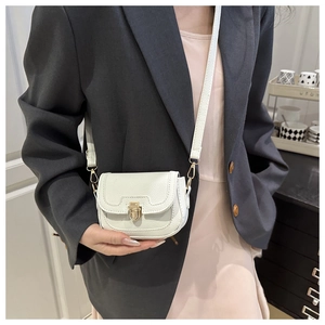 Detail of white lychee pattern leather crossbody bag with golden metal buckle