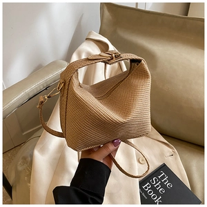 Detail of khaki woven texture handbag with golden hardware and adjustable strap