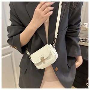 Detail of white lychee texture crossbody bag with gold metal buckle on female model