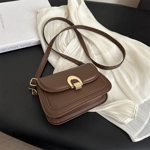 Klassische dunkelbraune Leder-Satteltasche mit goldener Hufeisenschnalle und Gurt